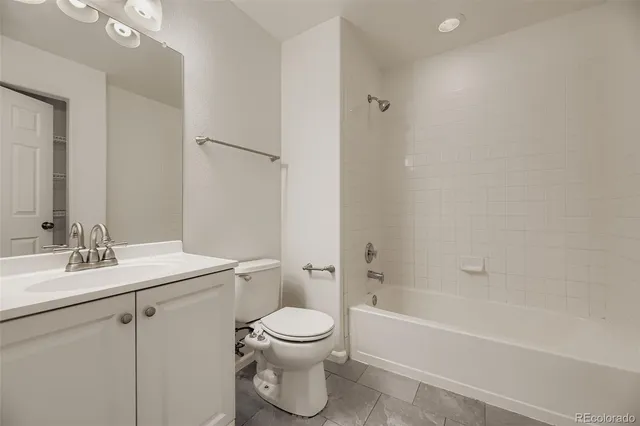an empty room with a chandelier fan and windows