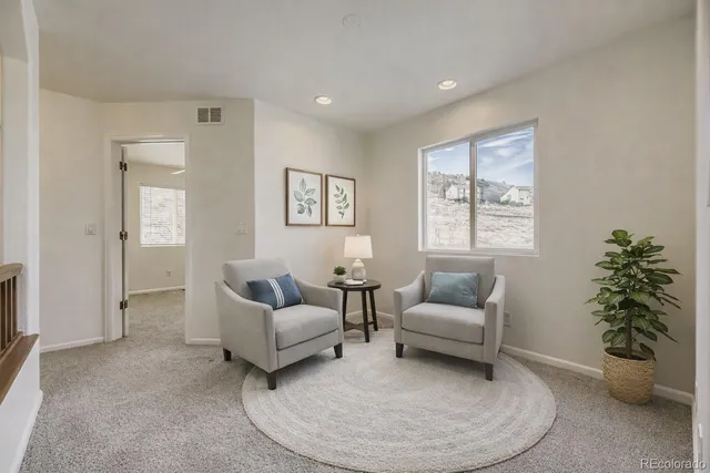 a living room with furniture and a potted plant