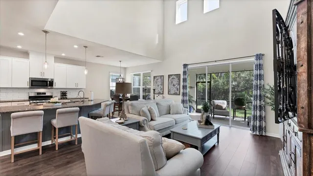 a living room with furniture wooden floor and a large window