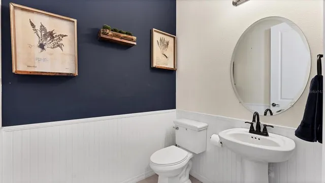 a bathroom with a toilet a sink and mirror