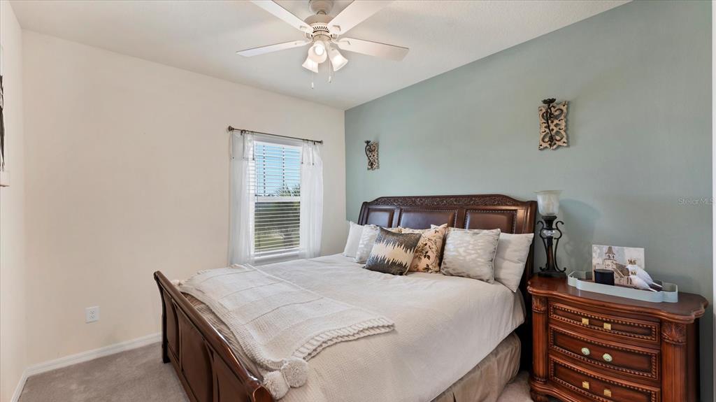 5935 Maidenstone Way Palmetto, FL 34221 - Photo 28 of 52 a bedroom with a bed and a chandelier