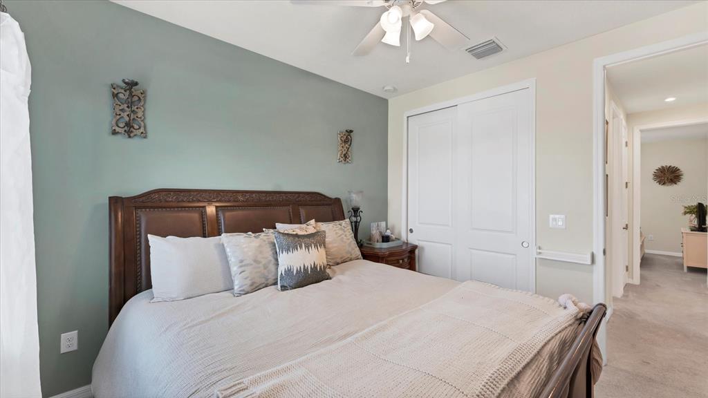 5935 Maidenstone Way Palmetto, FL 34221 - Photo 29 of 52 a bedroom with a bed and a chandelier