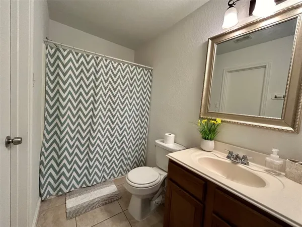 a bathroom with a granite countertop toilet a sink and a mirror