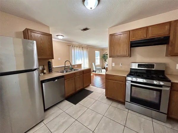 a kitchen with stainless steel appliances granite countertop a refrigerator sink and stove