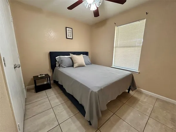 a bedroom with a bed and a ceiling fan