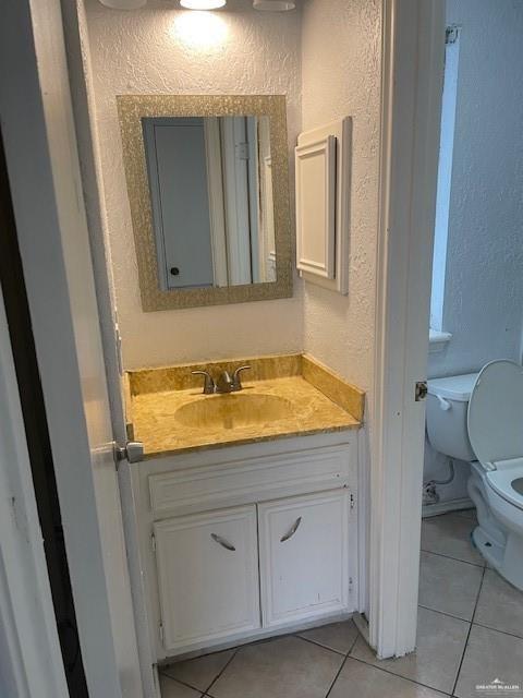 2432 West Iris Avenue McAllen, TX 78501 - Photo 14 of 16 a bathroom with a granite countertop sink and a toilet