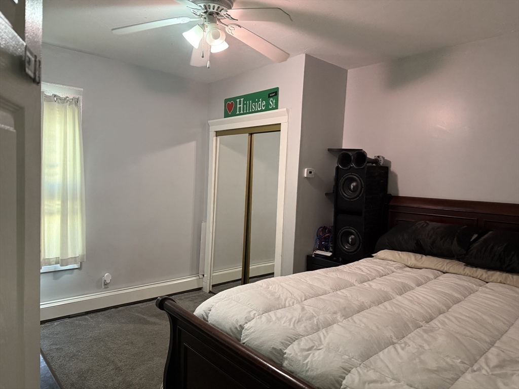 195 Millbury Street Worcester, MA 01610 - Photo 16 of 25 a bedroom with a bed and a chandelier