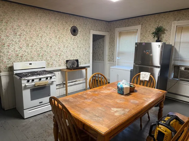 a kitchen with a table chairs and a refrigerator