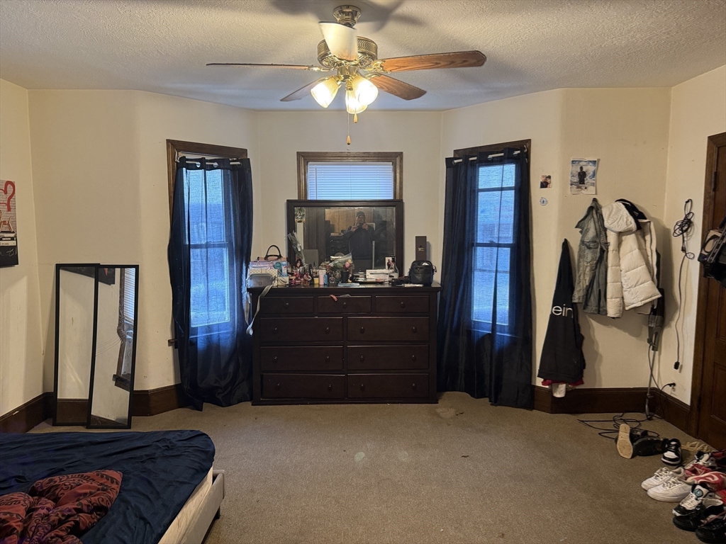 195 Millbury Street Worcester, MA 01610 - Photo 25 of 25 a room with a bed and a chandelier