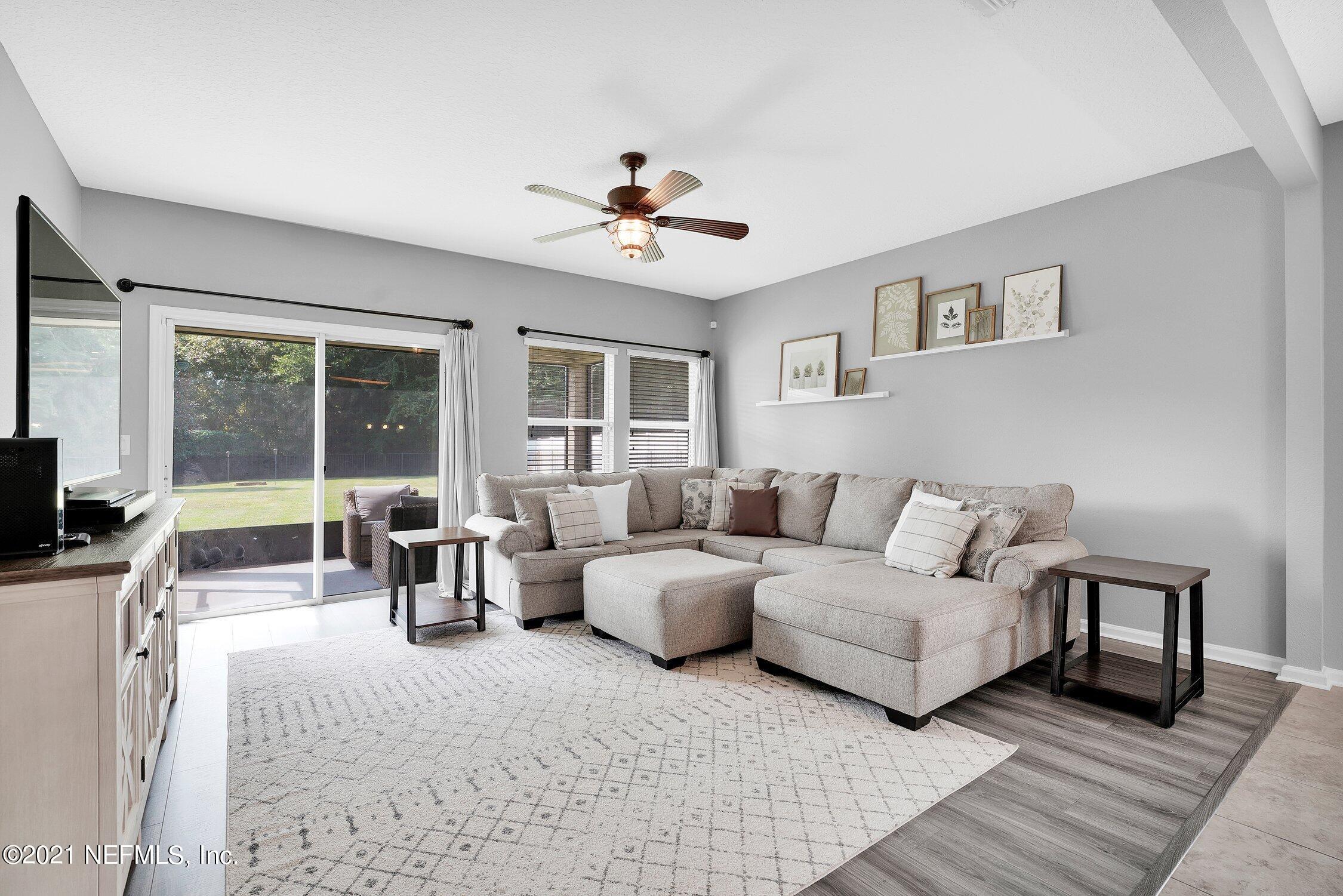 16342 Tisons Bluff Road Jacksonville, FL 32218 - Photo 13 of 57 a living room with couches a coffee table and a flat screen tv