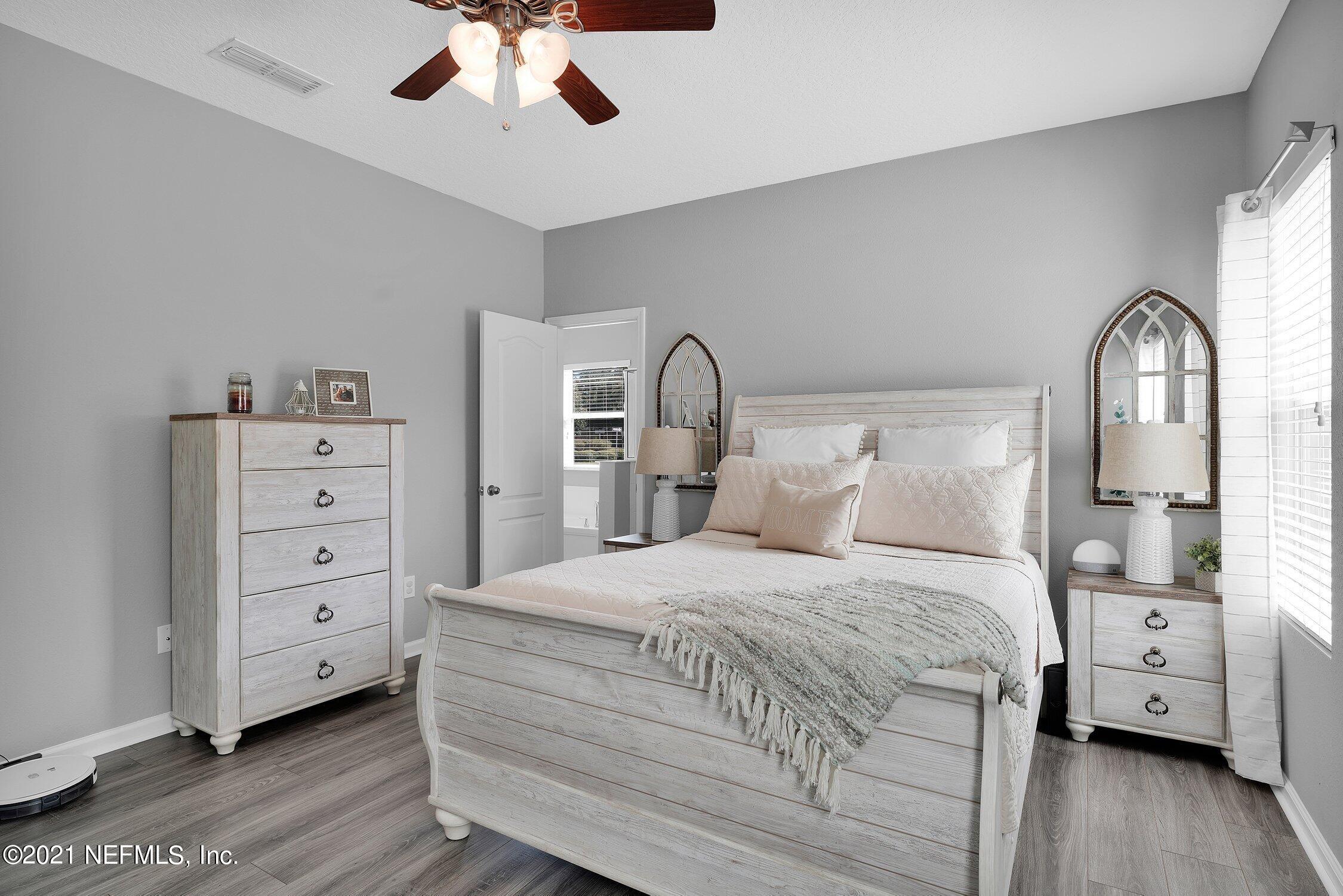 16342 Tisons Bluff Road Jacksonville, FL 32218 - Photo 17 of 57 a bedroom with a bed and a chandelier