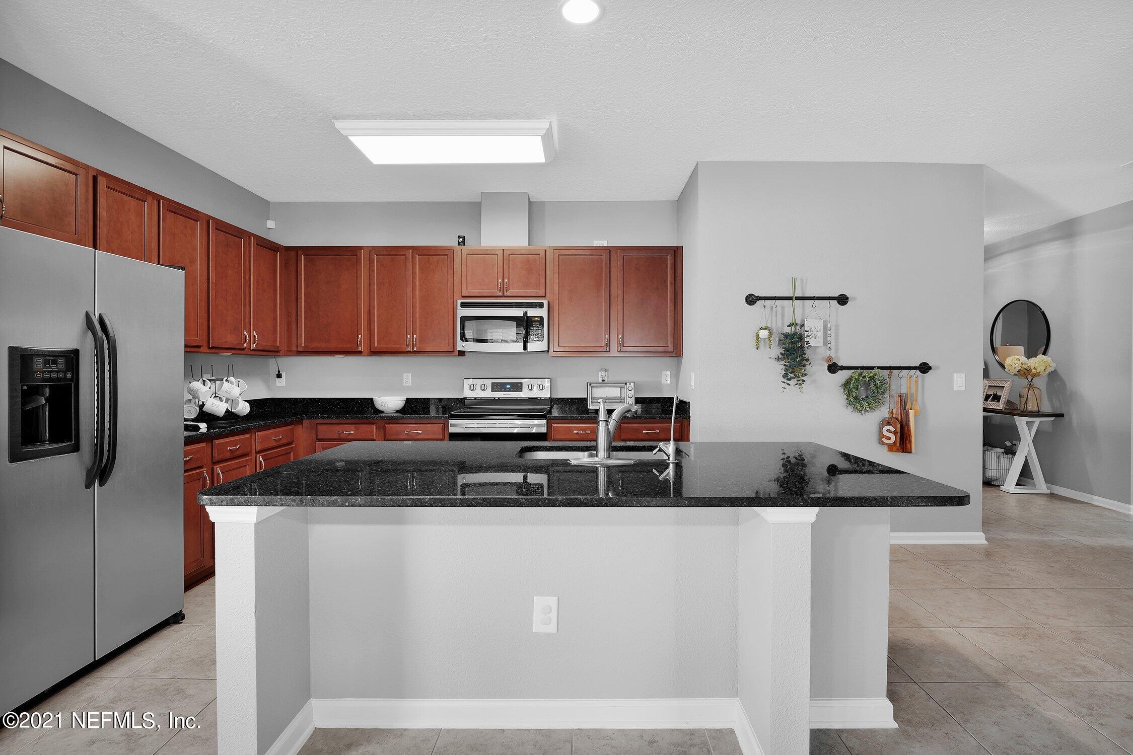 16342 Tisons Bluff Road Jacksonville, FL 32218 - Photo 8 of 57 a kitchen with stainless steel appliances granite countertop a stove a sink a refrigerator a microwave and cabinets