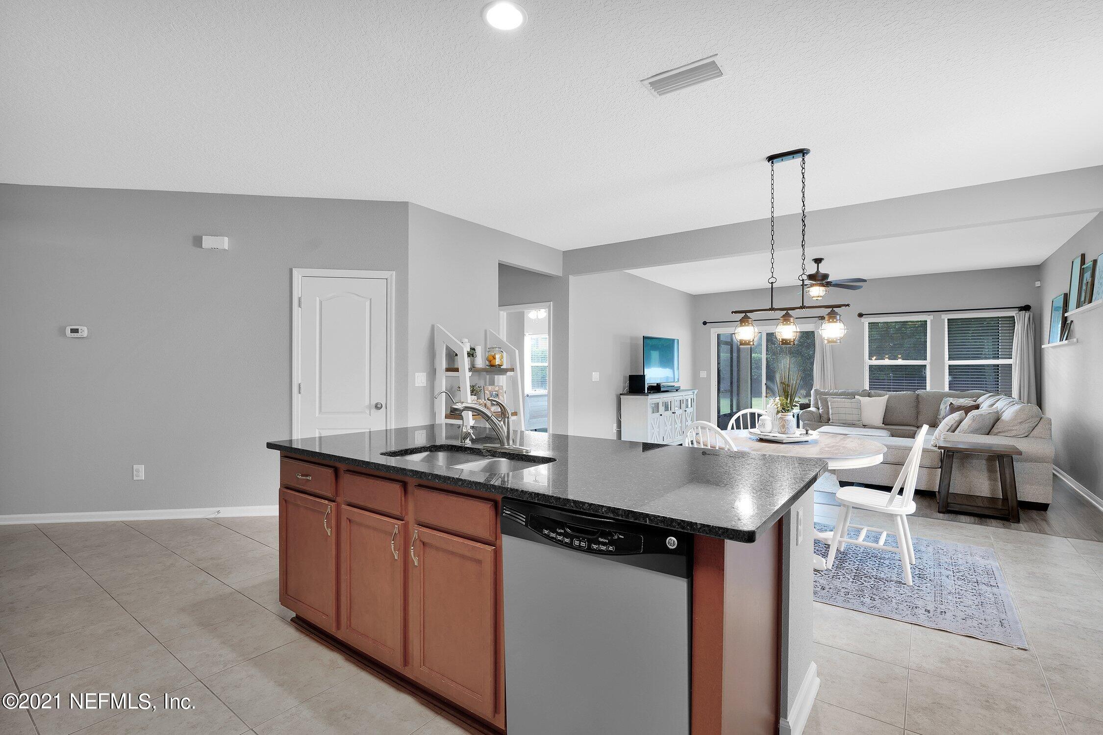 16342 Tisons Bluff Road Jacksonville, FL 32218 - Photo 10 of 57 a kitchen with kitchen island granite countertop a sink cabinets and chandelier