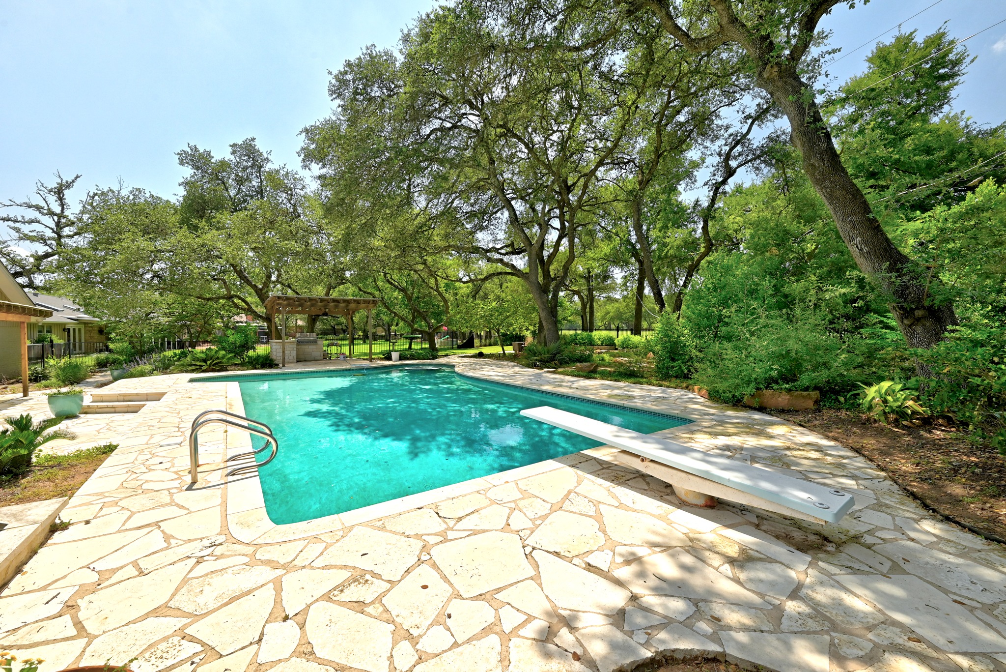 8608 Crest Ridge Circle Austin, TX 78750 - Photo 30 of 38 A tranquil oasis awaits, complete with a diving board and ample space for lounging beneath mature trees.