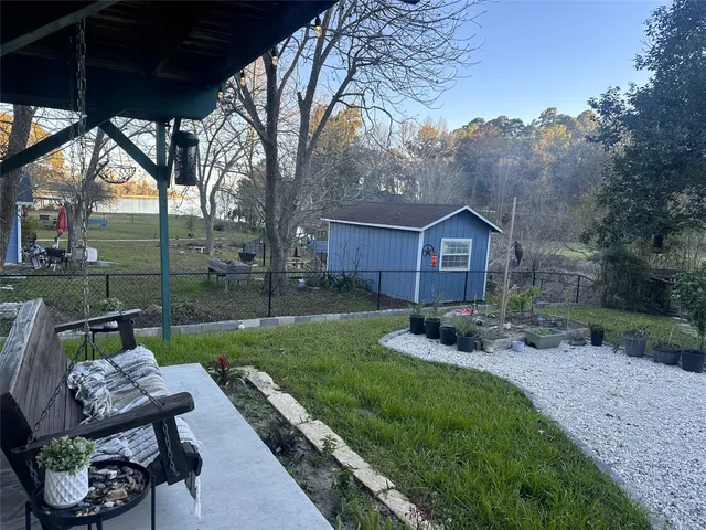 a view of a chair and table in backyard of the house