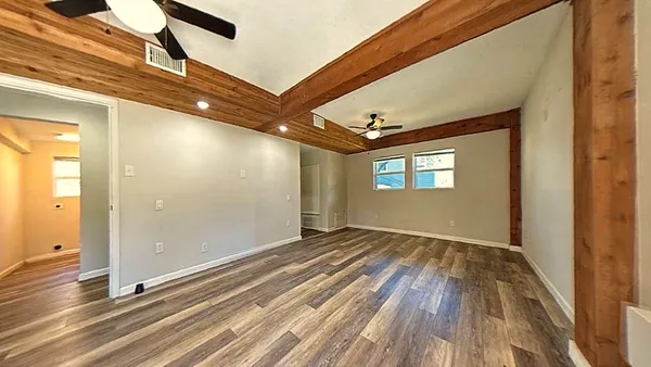 a view of empty room with window and wooden floor