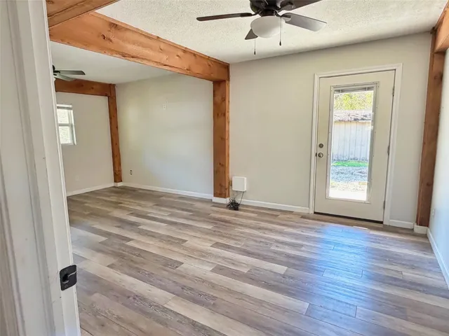 a view of a livingroom with wooden floor and a ceiling fan