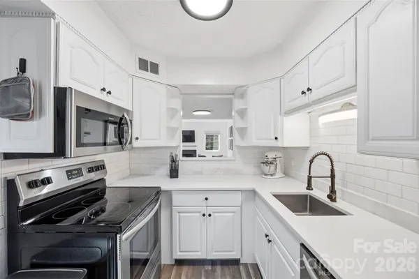 a kitchen with sink a stove and cabinets