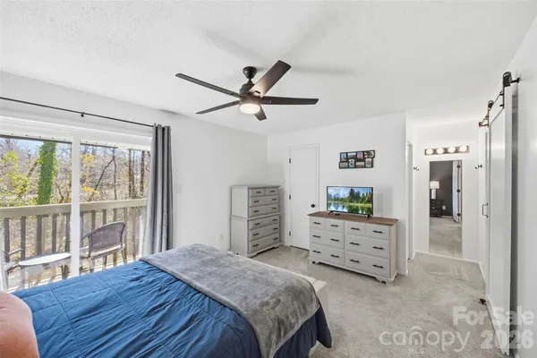 a bedroom with a bed a dresser and a large window