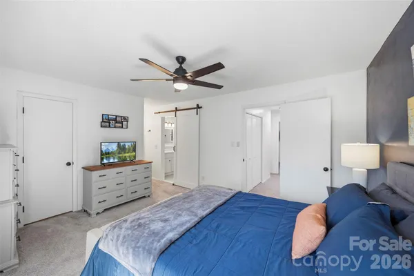 a spacious bedroom with a bed and a chandelier