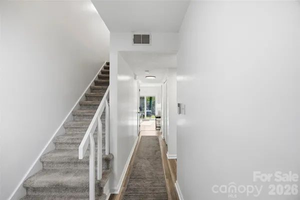 a view of a hallway with wooden floor and entryway