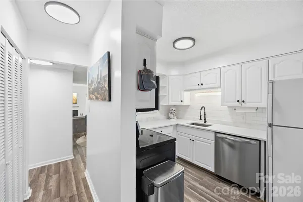 a kitchen with a sink dishwasher a refrigerator and cabinets