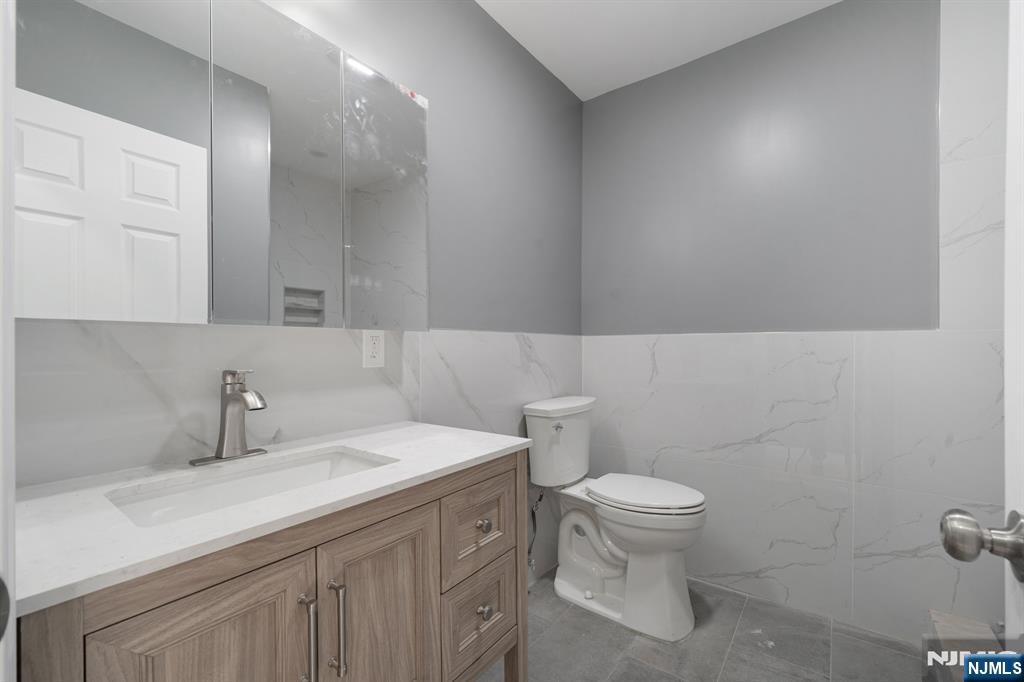 149 Florence Avenue, Unit 2 Hawthorne, NJ 07506 - Photo 3 of 9 a bathroom with a sink a toilet and a mirror