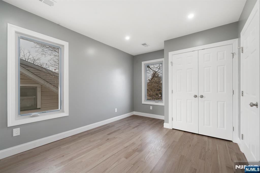149 Florence Avenue, Unit 2 Hawthorne, NJ 07506 - Photo 4 of 9 a view of an empty room with wooden floor and a window