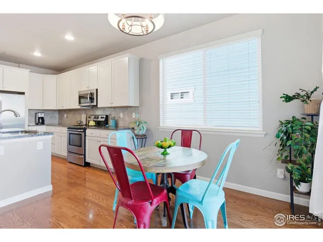 a open dining room with furniture a potted plant and a kitchen view
