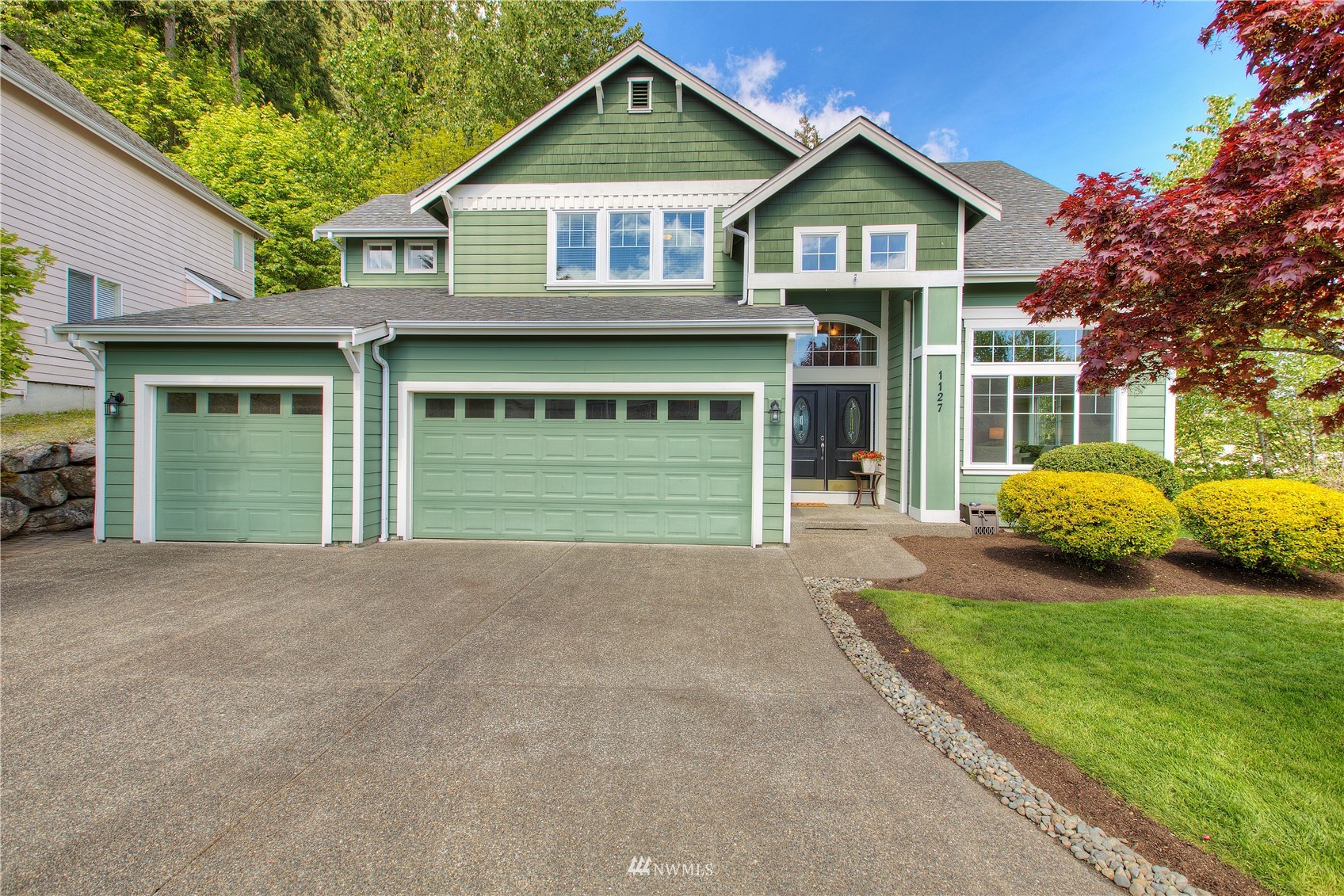 a front view of a house with a yard and garage