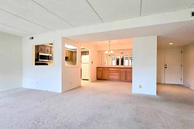 a view of a kitchen with granite countertop cabinets and chandelier