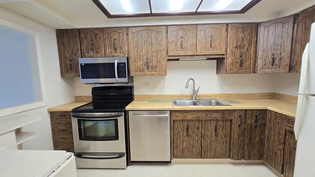 a kitchen with stainless steel appliances a stove a microwave and a refrigerator