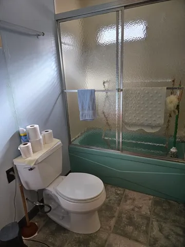 a bathroom with a toilet and a shower