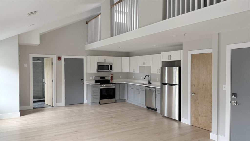 944 East Street, Unit 3 Walpole, MA 02081 - Photo 7 of 23 a kitchen with stainless steel appliances granite countertop a refrigerator and a stove top oven