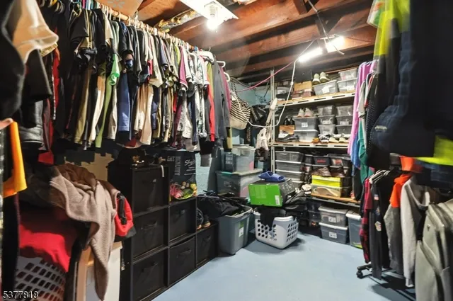 a view of walk in closet with clothes and shoes