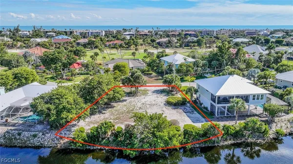 an aerial view of a houses with a yard and lake view