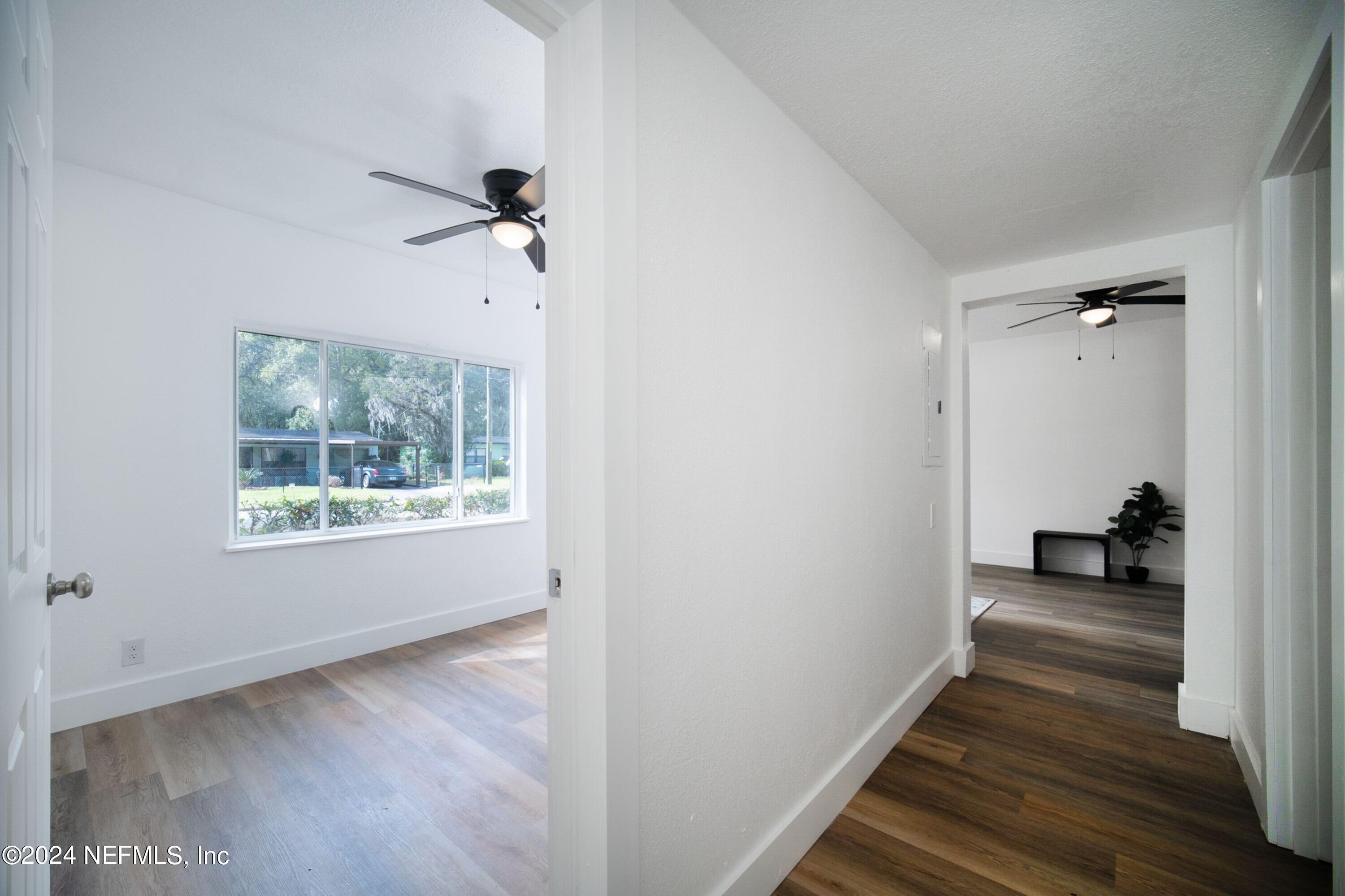 2589 Springmont Street Jacksonville, FL 32207 - Photo 45 of 71 a view of a hallway with wooden floor and a bathroom