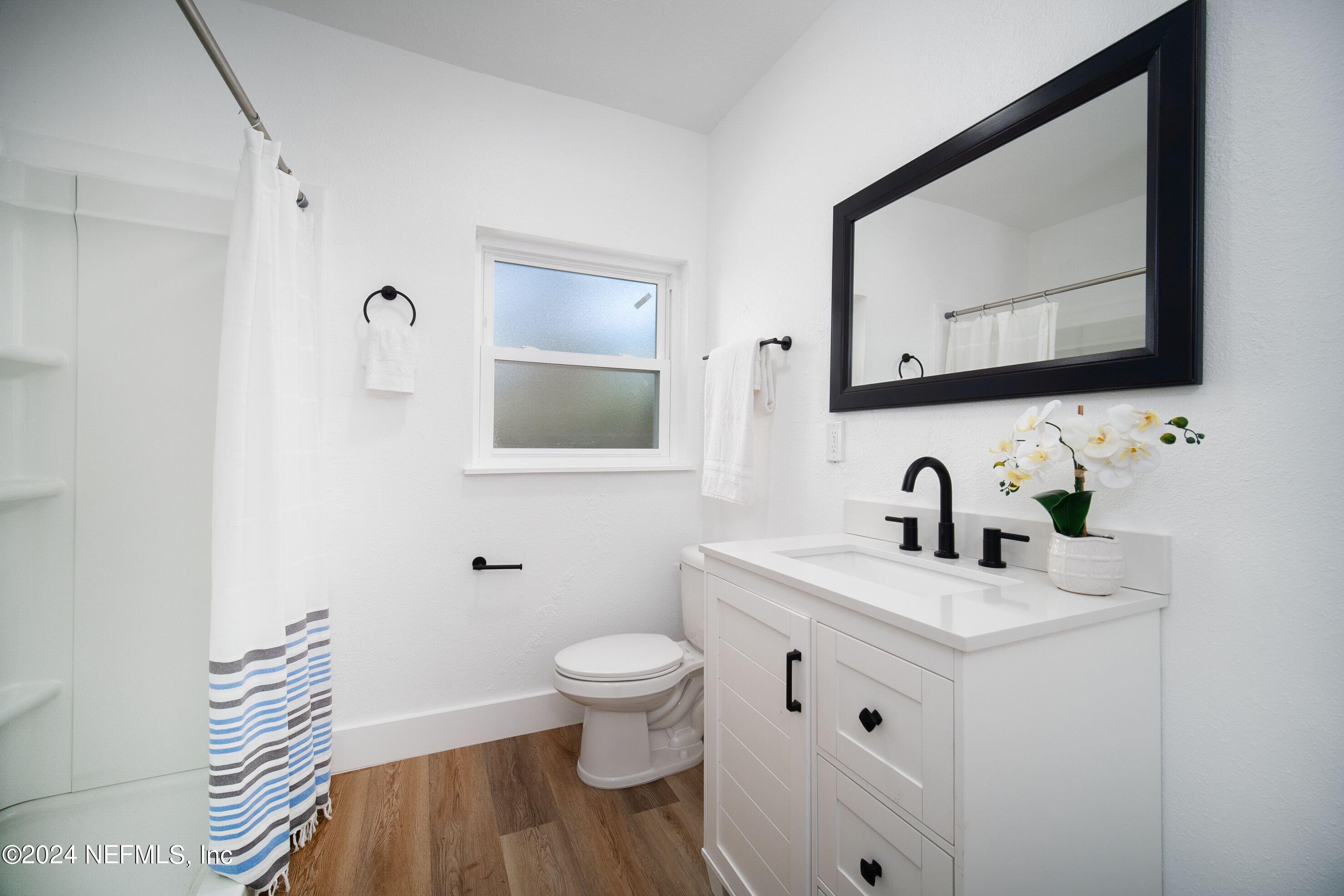 2589 Springmont Street Jacksonville, FL 32207 - Photo 5 of 71 a bathroom with a toilet sink double vanity and mirror