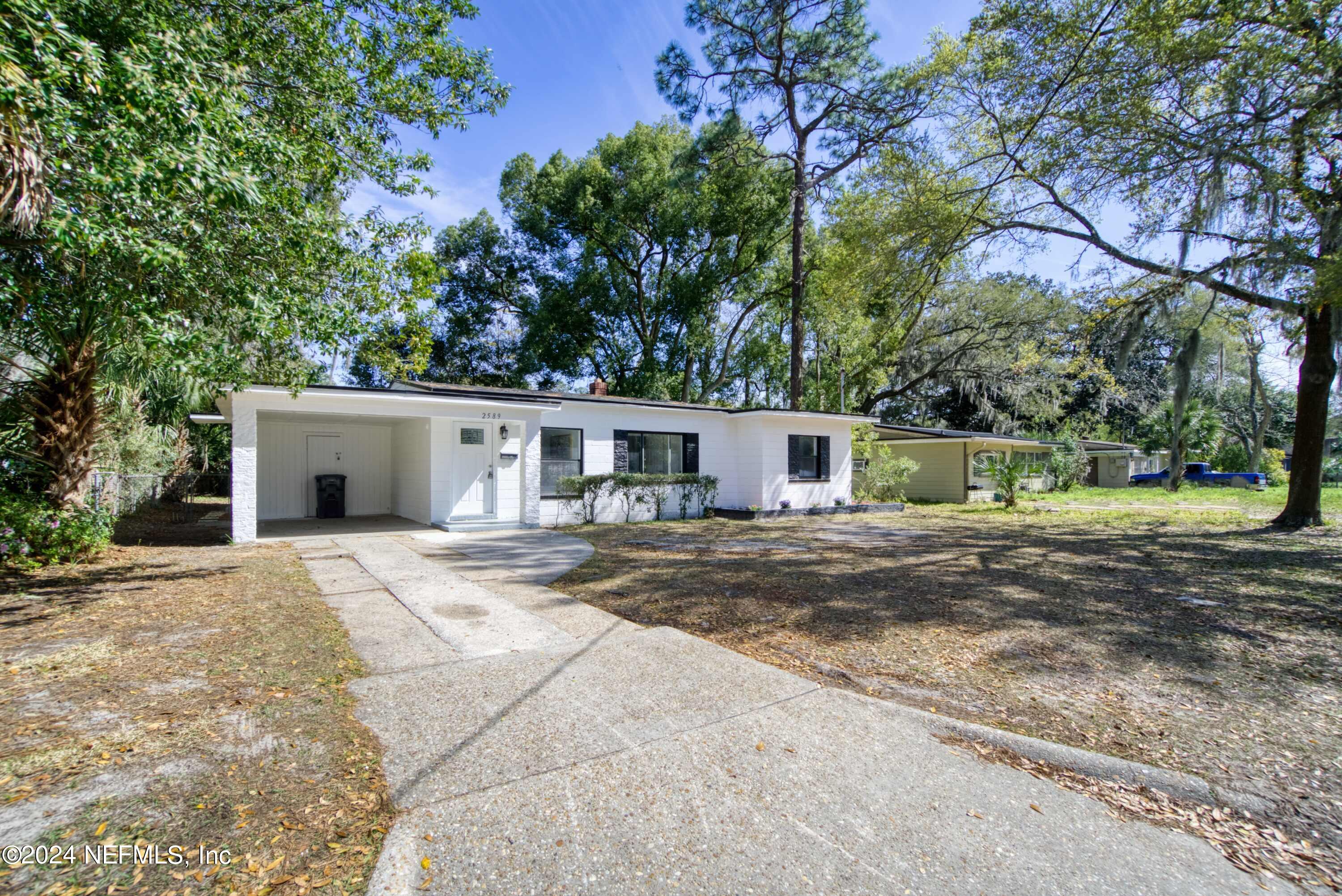2589 Springmont Street Jacksonville, FL 32207 - Photo 70 of 71 a view of a house with a yard and a garage