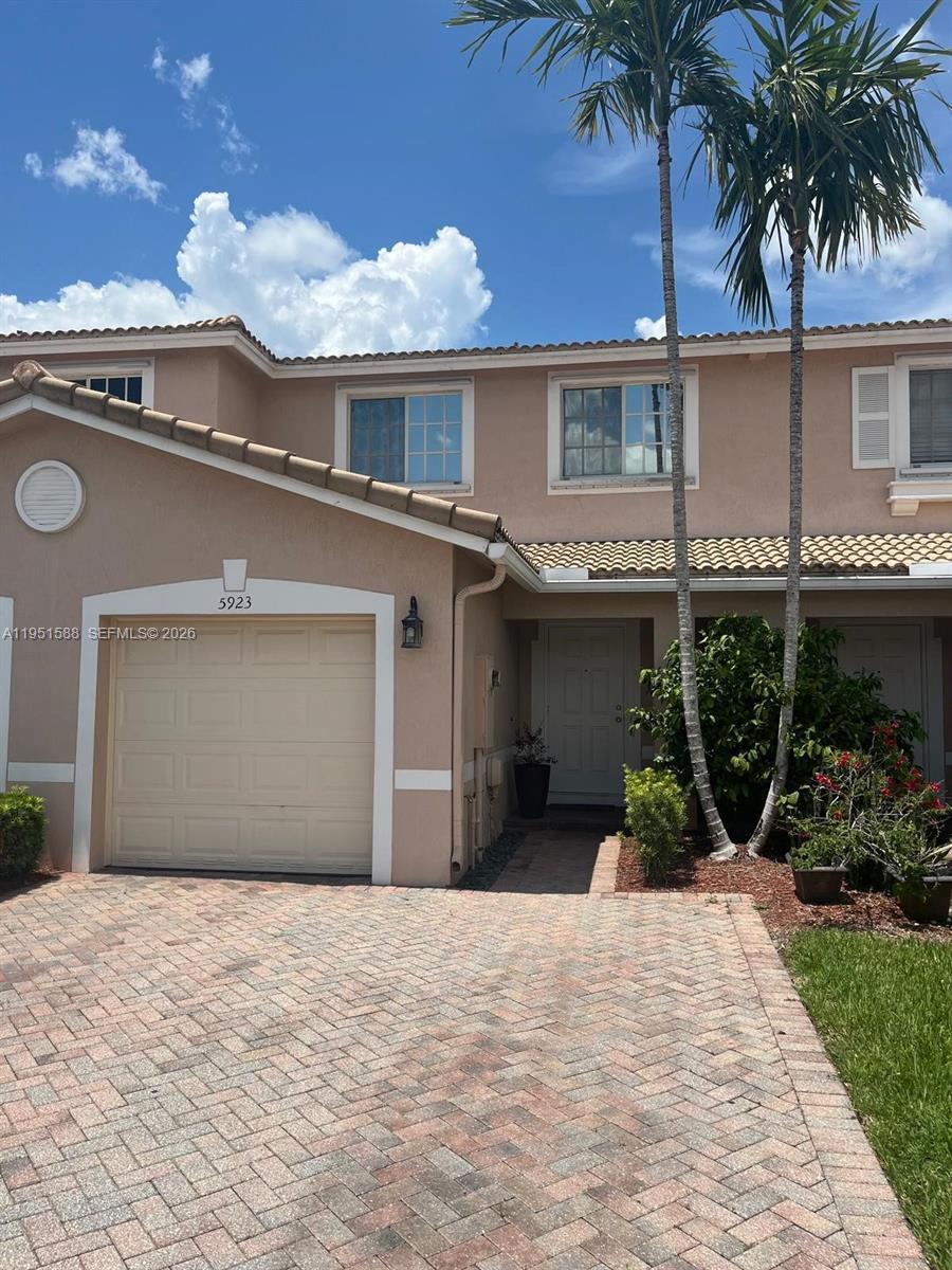 5923 Abbey Road, Unit 5923 Tamarac, FL 33321 - Photo 1 of 6 a front view of a house with a garden and patio