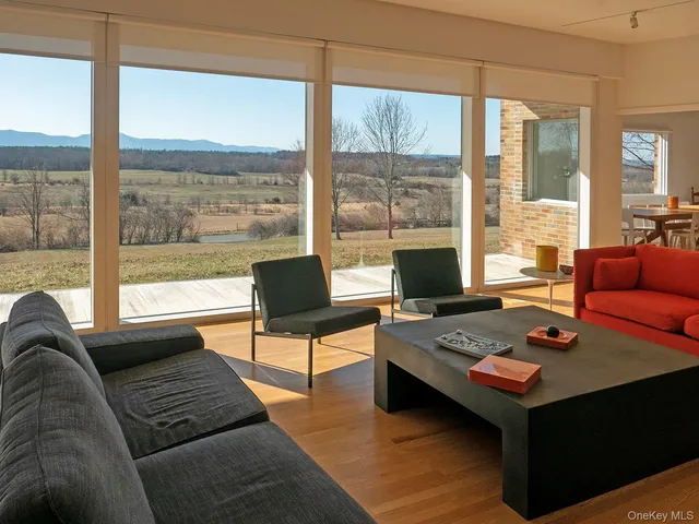 a living room with furniture a table and a large window