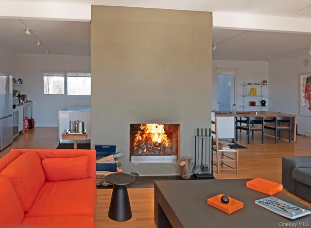 a living room with furniture and a flat screen tv with kitchen view
