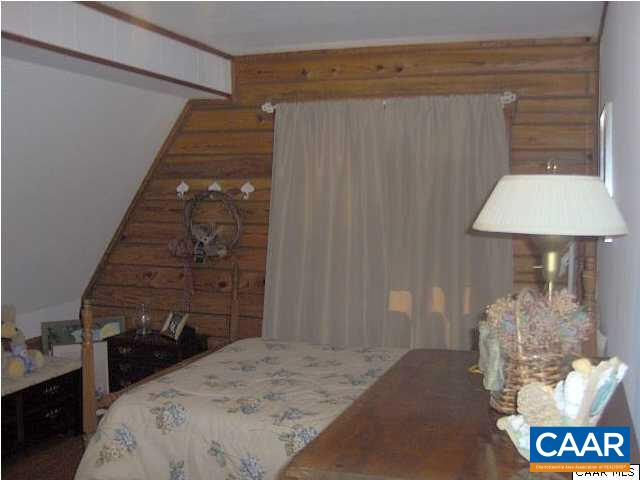 6037 Bell Road Dillwyn, VA 23936 - Photo 8 of 8 a bedroom with a bed and a table with chair