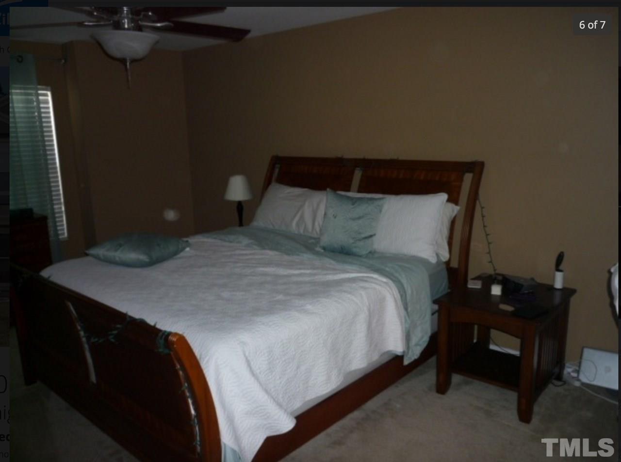 3025 Varcroft Road Knightdale, NC 27545 - Photo 6 of 7 a bed sitting in a bedroom next to a lamp