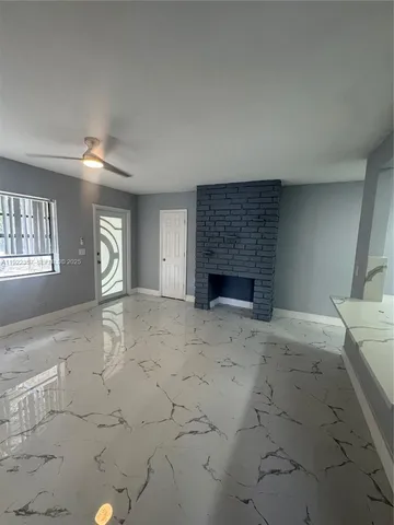 an empty room with windows and fireplace