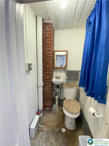 a white toilet sitting next to a shower curtain