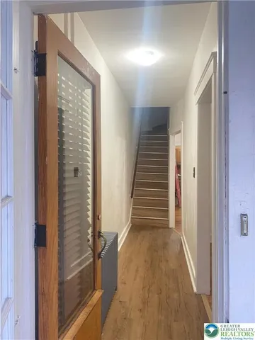a view of a hallway with wooden floor and staircase