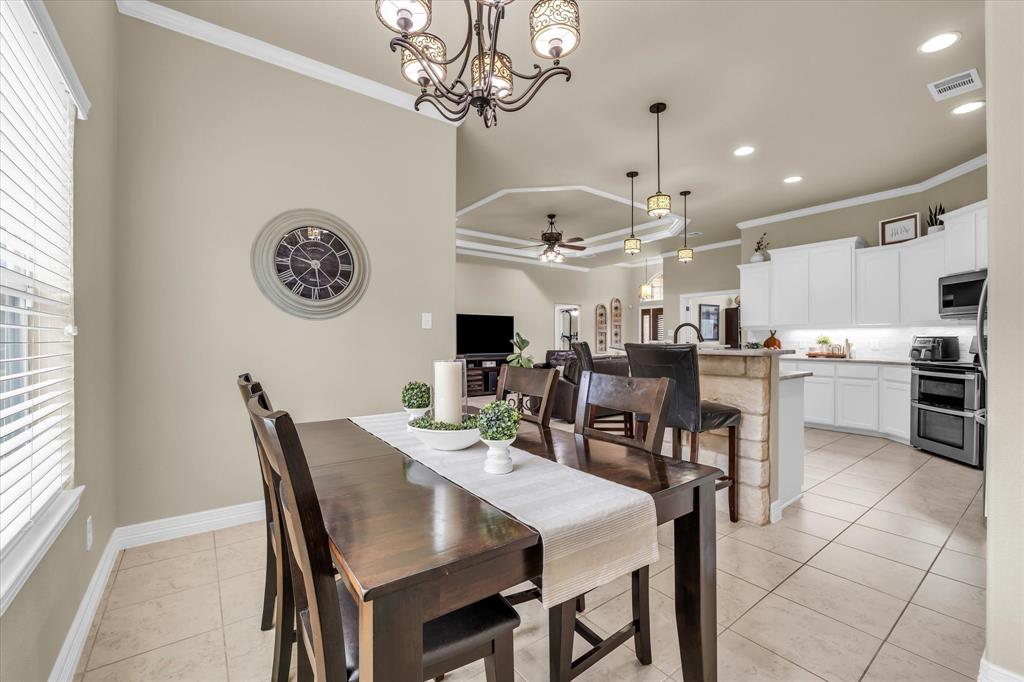 910 Springdale Lane Lorena, TX 76655 - Photo 11 of 39 Dining area featuring a decorative chandelier, crown molding, and tiled flooring