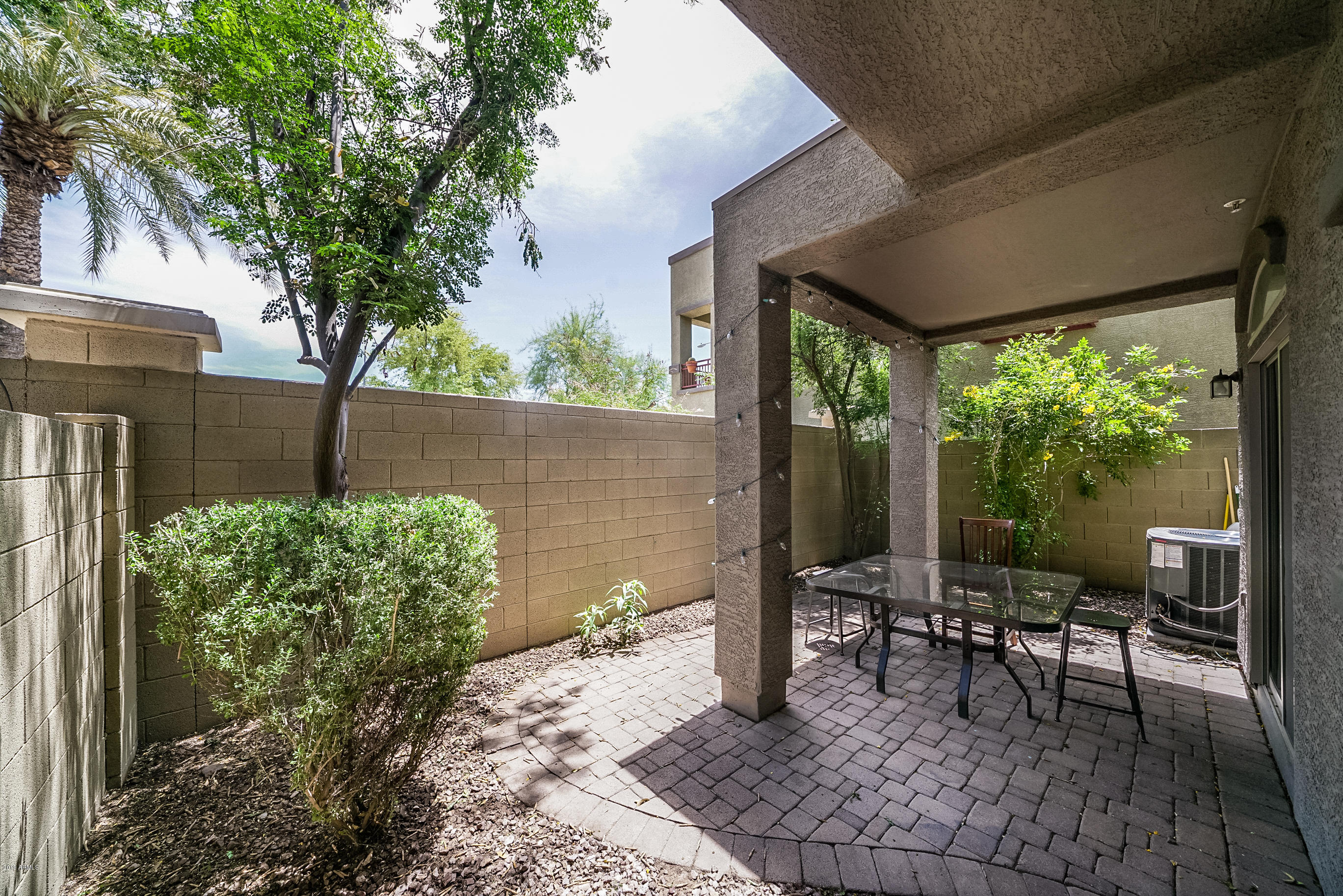 280 South Evergreen Road, Unit 1229 Tempe, AZ 85288 - Photo 24 of 31 a view of a patio with table and chairs potted plants and large tree
