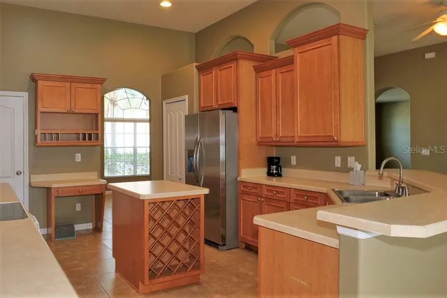 a kitchen with stainless steel appliances a refrigerator a sink a stove and island